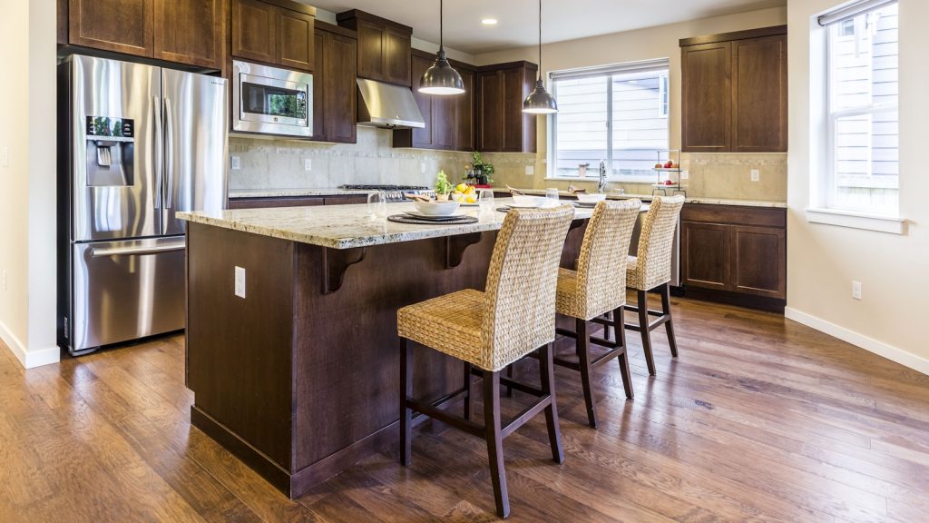 Cuisine chaleureuse avec un sol en parquet bois et îlot central