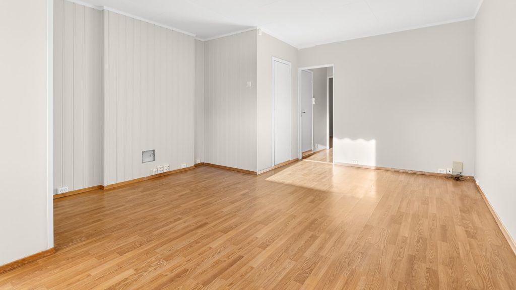 Pièce vide avec un parquet en chêne à rénover baignée de lumière
